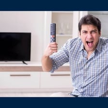 A person unplugging a cable from the back of a television.