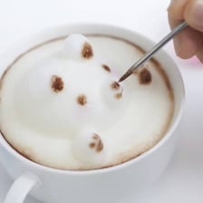 A foamy latte served in a ceramic coffee cup.