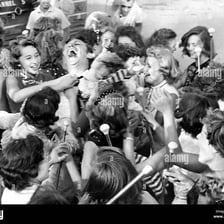 Several background actors appearing in a crowd scene on a film set.