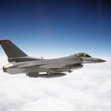 An F-16 Fighting Falcon flying through the air.