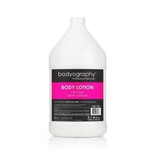 A person making a hand gesture beside a bottle of body lotion