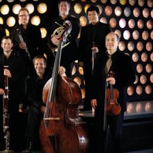 Eight musicians performing together as an ensemble.