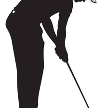 A golfer setting a ball on a tee before making a drive.