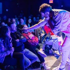 A comedian delivering a sharp humorous roast onstage