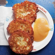Golden potato latkes served with applesauce during Hanukkah.