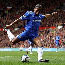 A soccer player kicking the ball toward a goal