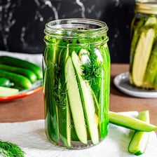 Pickling cucumbers submerged in salty brine inside a jar