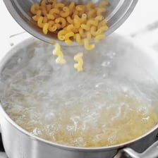 A pot of water boiling on a stovetop, ready for pasta