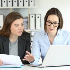 Two people comparing objects that belong to each of them