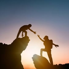 One person reaching out to help another person.