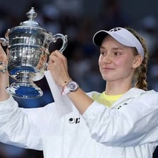 A tennis player celebrating a Grand Slam victory with a trophy