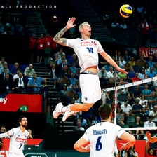 A volleyball player striking the ball forcefully over the net