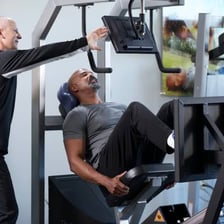 A fitness trainer coaching a person during a workout.
