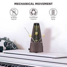 A mechanical metronome standing beside sheet music