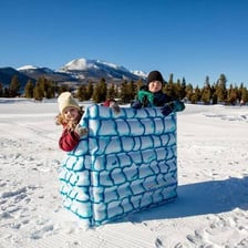 A small fort made of snow that people could use for cover in a snowball fight.