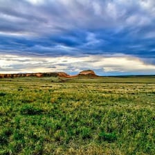 A broad open field extending across a landscape.