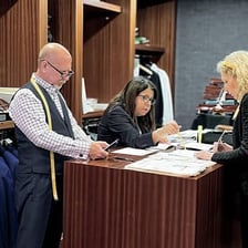 A tailor measuring a customer for a custom-made suit