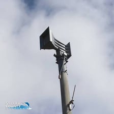 An emergency warning siren mounted on a pole outdoors.