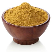 Small brown cumin seeds in a bowl beside curry spices.