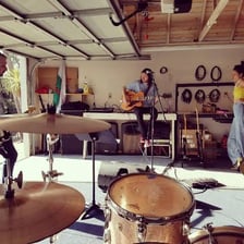 A small rock band playing music in a garage
