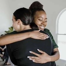 One person comforting another with a supportive embrace.