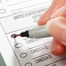 A voter marking a ballot at a polling place.