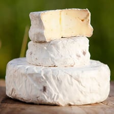 A round wheel of Brie cheese with its characteristic pale rind.