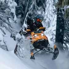 A Ski-Doo snowmobile traveling across snow.