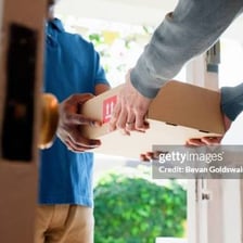 A person handing off a package for delivery.