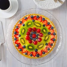 A fruit tart displayed in a French pastry shop.
