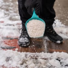 Road salt scattered across an icy winter roadway
