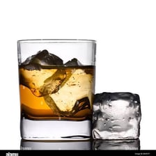A whiskey glass served over ice cubes.