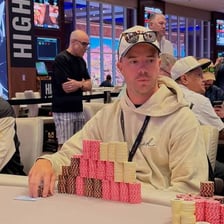 Poker players putting betting chips into the center of the table
