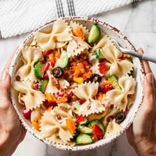 A bowl of pasta salad served outdoors at a cookout.