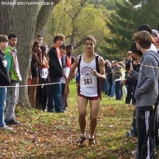 A competitor narrowly crossing a finish line ahead of the others.