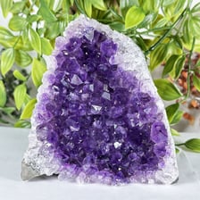 An opened geode showing crystals inside its rocky exterior.