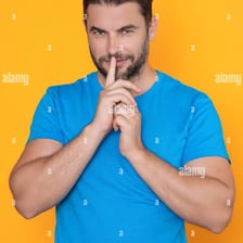 A person holding one finger to their lips in a request for silence.