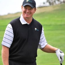 Ernie Els playing golf on a course.