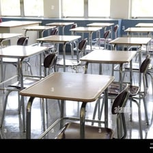 Rows of individual desks in a school classroom