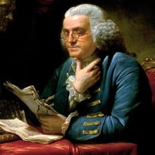 A historical-style image of bifocal eyeglasses associated with Benjamin Franklin.