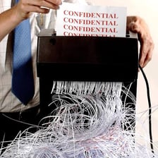 Documents being fed into a paper shredder.