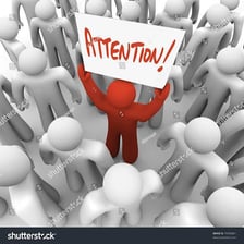 A person waving to attract attention in a crowd.