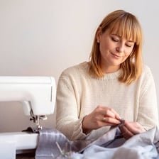 A person sewing fabric by hand