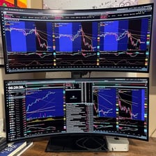 A trader viewing financial charts on computer monitors.