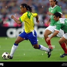 Ronaldinho performing a dribbling move on a soccer field.