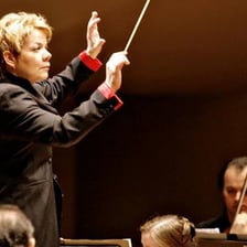 A conductor leading an orchestra during a symphonic performance.