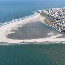 An aerial view of a narrow coastal inlet between rocky shores.