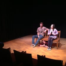 An actor onstage responding to a theatrical cue.