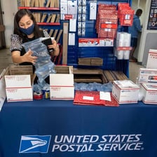A person sending a packaged item through the mail.