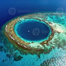 An aerial view of a ring-shaped coral atoll surrounding a lagoon.